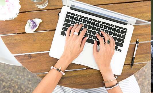 Professional woman working on laptop outdoors, demonstrating remote work flexibility